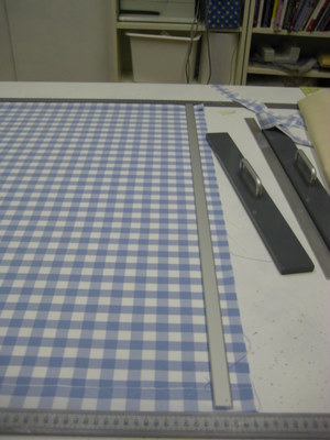Checked fabric being straigtened in workshop